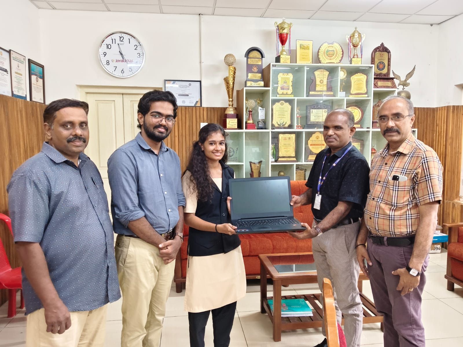Comfinity handing over a laptop at a Helping Hands presentation